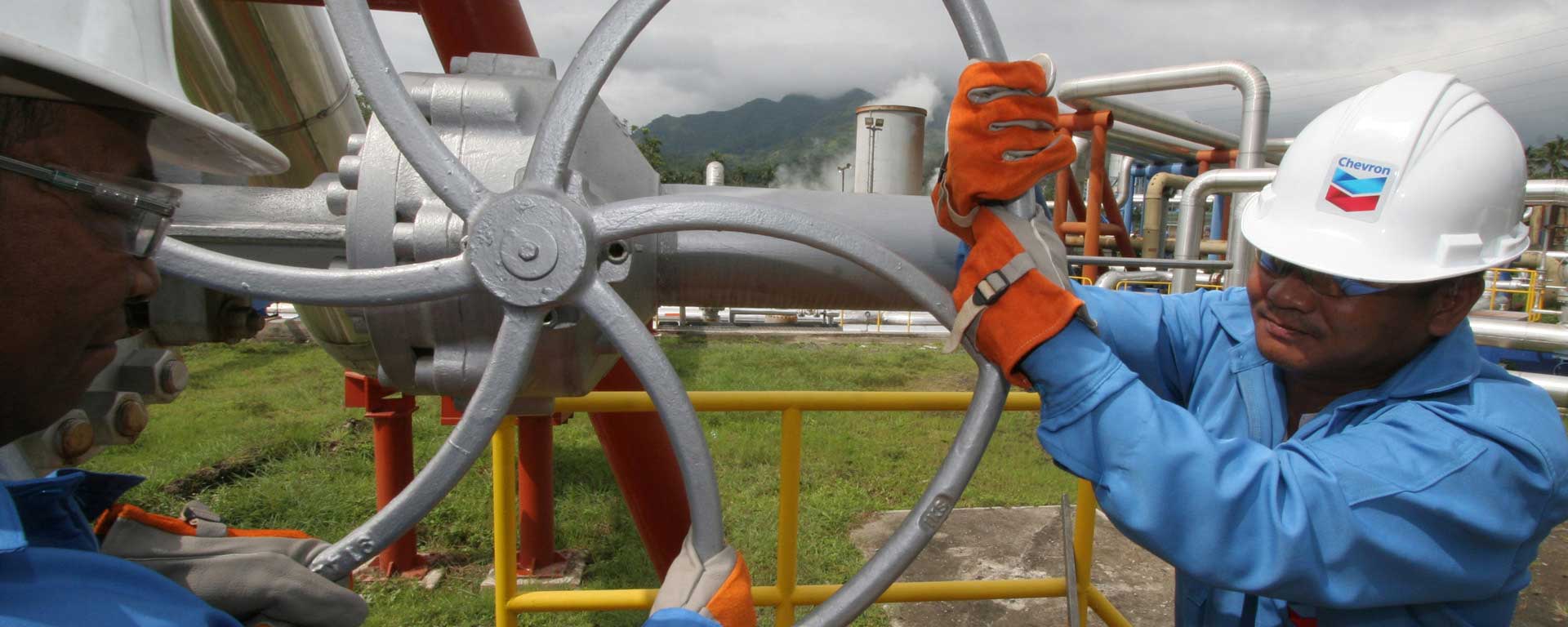 two workers turning a pipeline off in the Phillipines