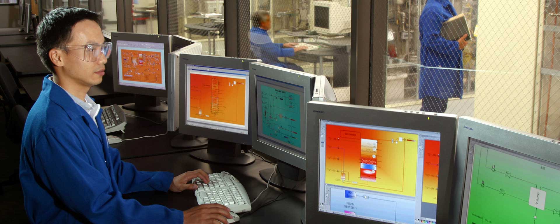 a computer technician working on various computer monitors