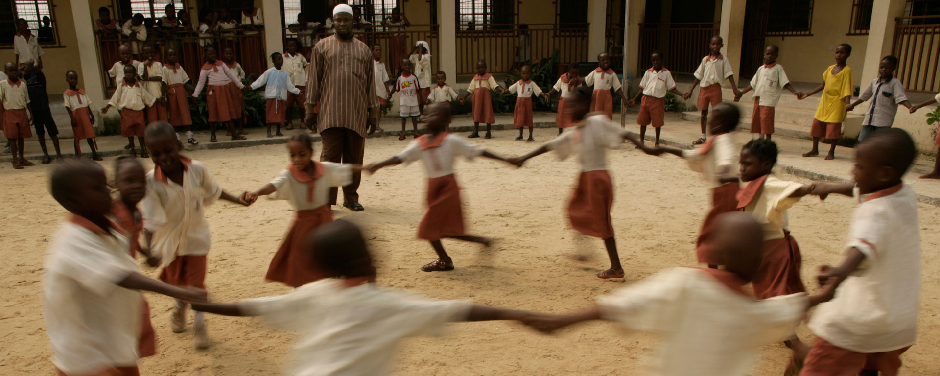 a group of children in Nigeria dancing in a circle