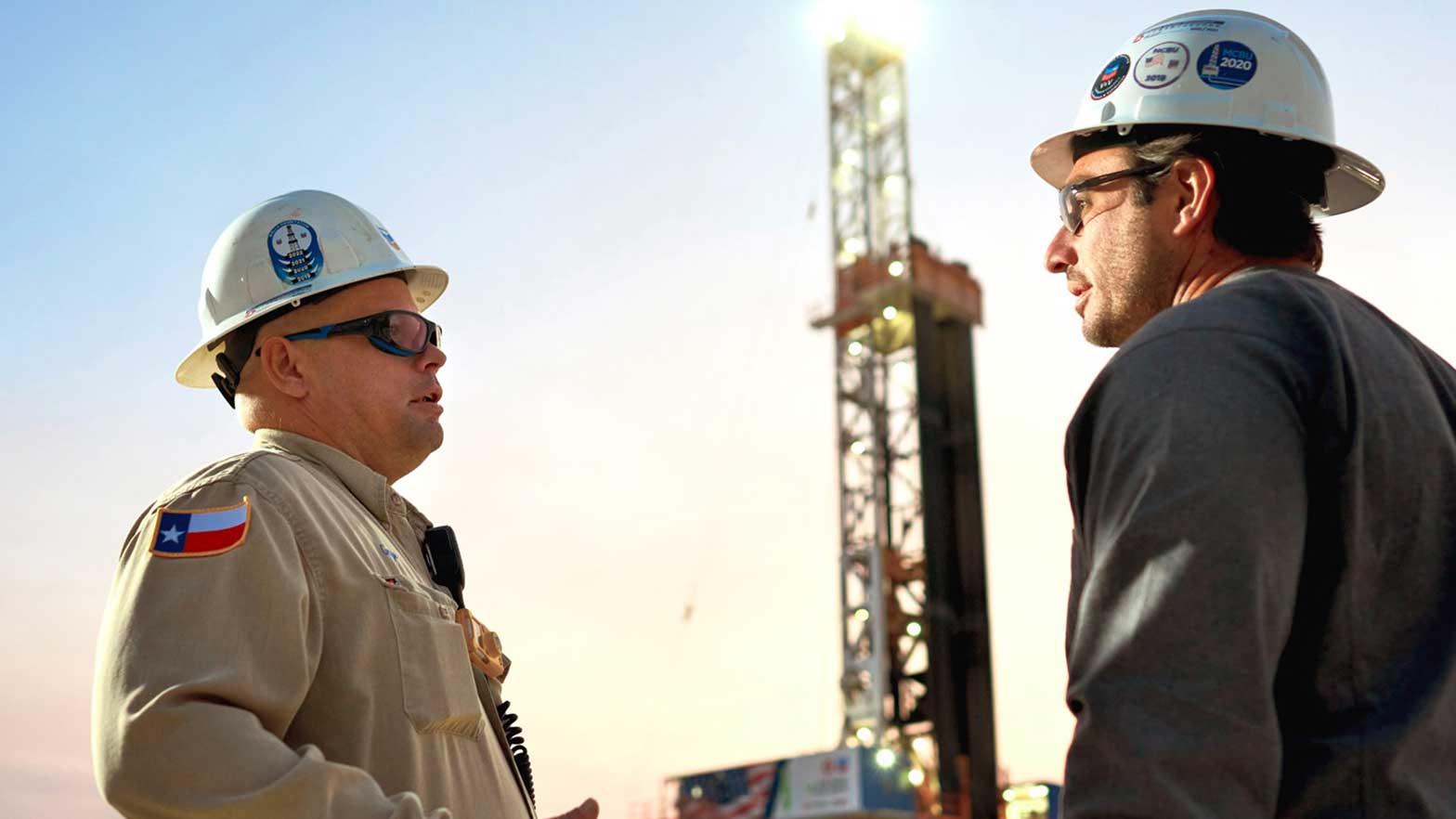 two chevron workers discuss the area and issues