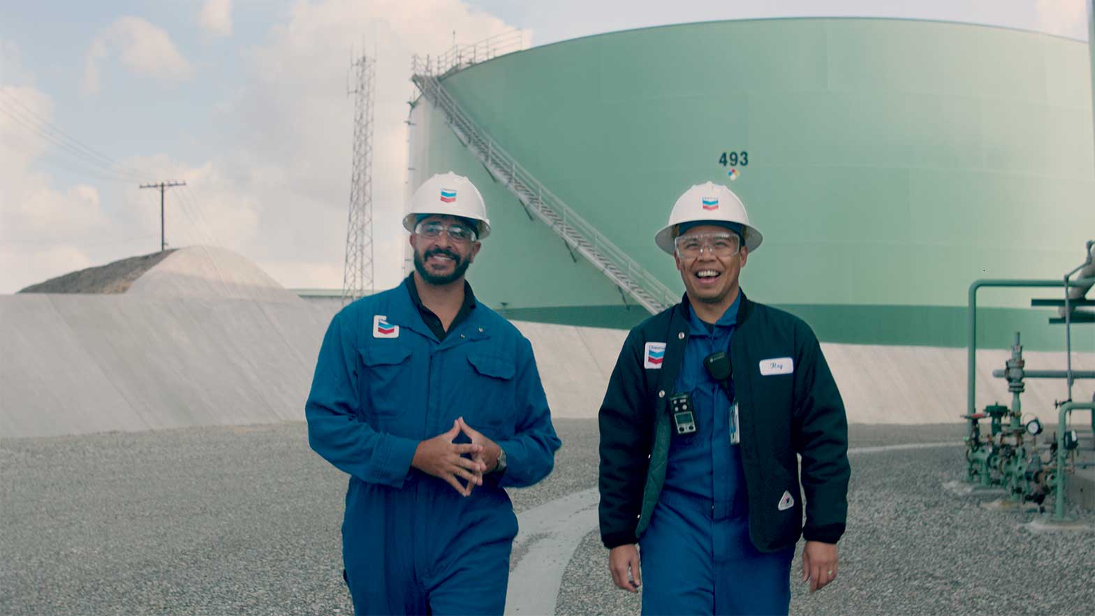 Hasbani (left) walking with Ray Obico near the vegetable oil tank at El Segundo Refinery in California.