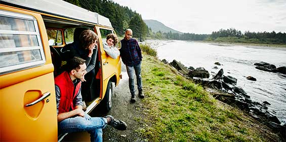 a group of travelers in their van looking at the river