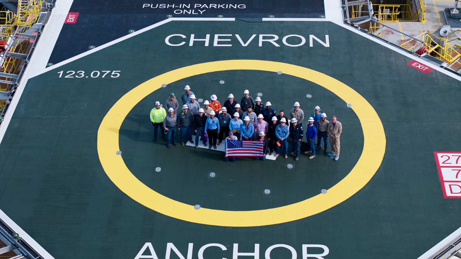 Project team members celebrating the sail away milestone on the Anchor helipad.
