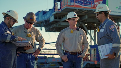Four workers in hardhats at electric rig