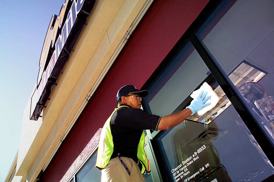 Chevron worker disinfecting retail store entry-way