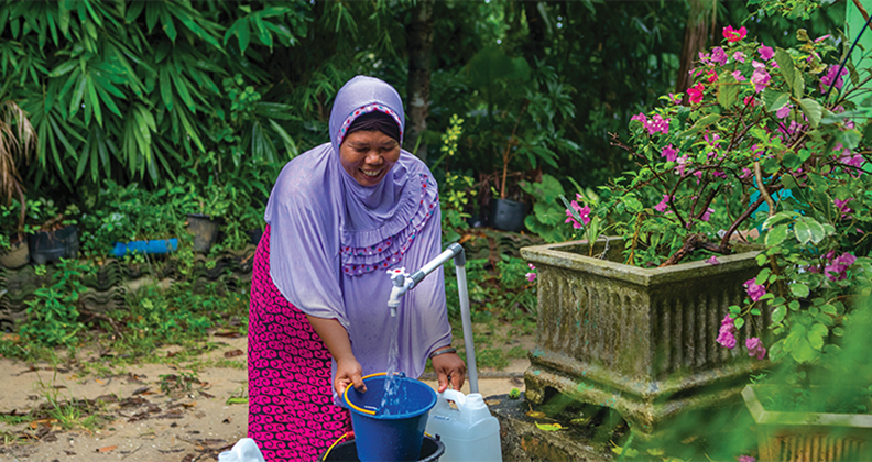 woman at water well in Indonesia
