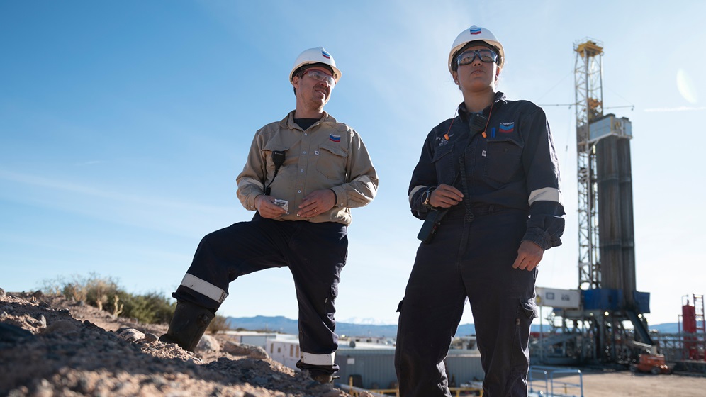 Two Employees standing near an oil rig